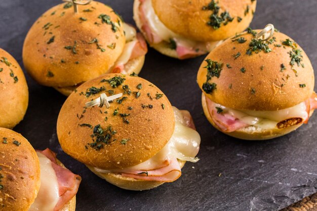 Sliders de jambon et de fromage sur des petits pains faits maison.