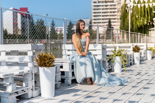 Slim jeune femme en robe d'été posant au paysage de la ville