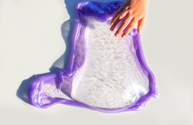 Slime scintillant transparent dans une main