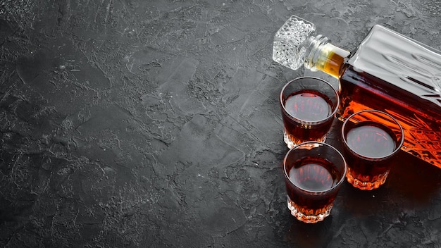 Slivovica prune vodka prune brandy dans une bouteille sur une table en pierre noire Verres avec boisson alcoolisée Vue de dessus Espace libre pour votre texte