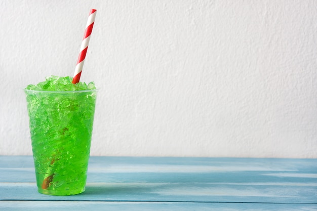 Slushie verte sur une table en bois bleue