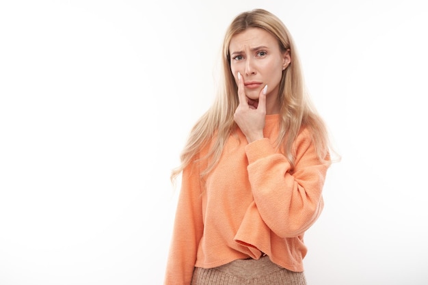 Smart blonde girl in casual holding menton pense doutes rend décision isolé sur fond blanc studio