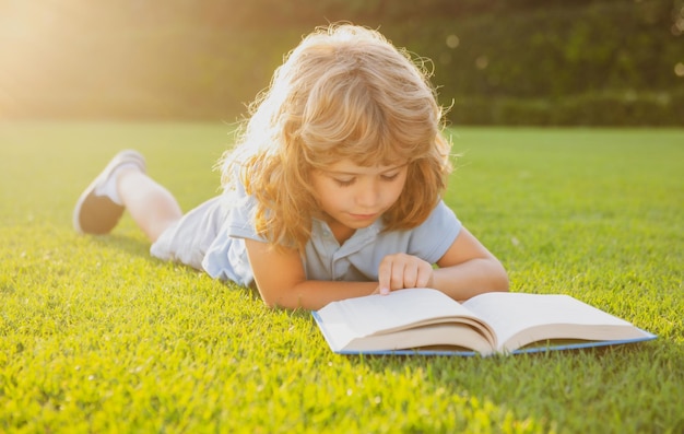 Smart smart Kids Mignon joli enfant lisant un livre à l'extérieur Kid lire un livre dans le parc Summer outdoor kids education