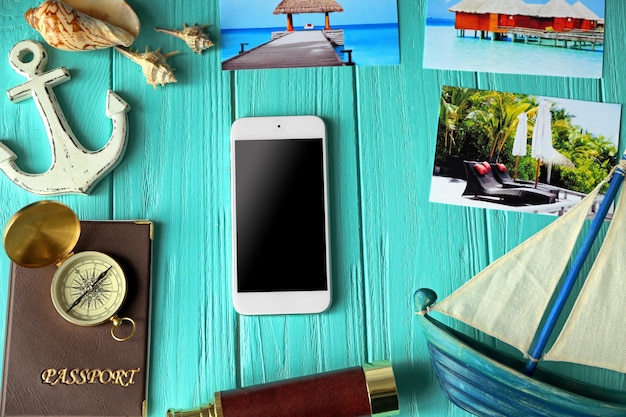 Smartphone et accessoires de planification de voyage sur fond de bois