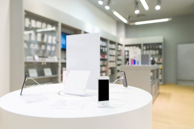 Photo smartphone sur l'arrière-plan d'un magasin de technologie légère.