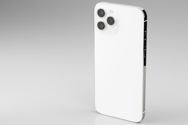 Smartphone blanc moderne avec appareil photo triplelens sur surface grise