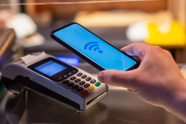 Smartphone en boutique utilisant la technologie NFC dans le contexte du terminal de paiement.