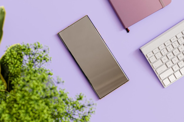 Photo smartphone sur un bureau avec une plante de table verte une clé large et un journal