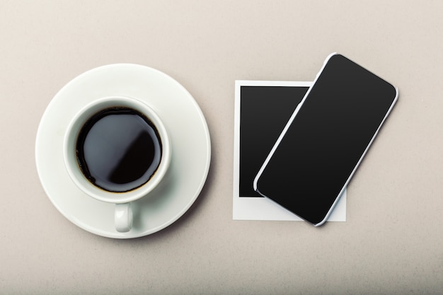 Smartphone à côté du café sur la table en bois.