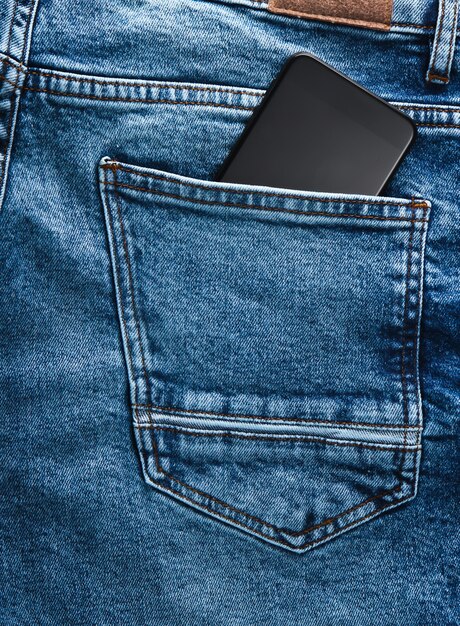 Smartphone dans la poche arrière d'un jean bleu