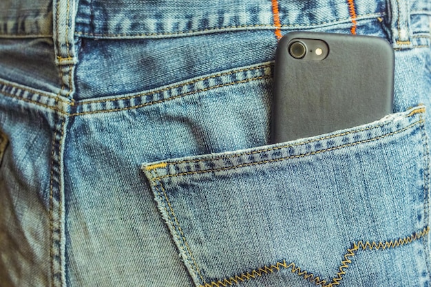 Smartphone dans la poche arrière d'un jean denim close up