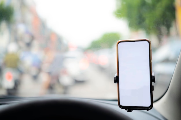Smartphone dans une voiture utilisée pour naviguer ou GPS Conduire une voiture avec Smartphone dans le support Téléphone portable isolé écran blanc Espace de copie d'écran vide vide Espace vide pour le texte détails intérieurs de la voiture