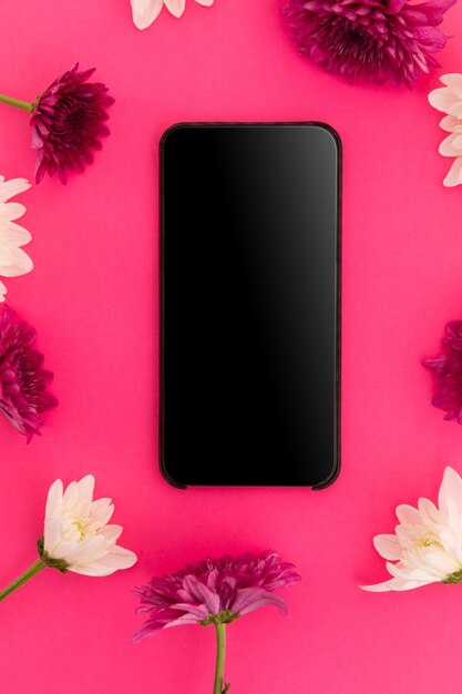 Photo smartphone avec écran blanc et fleurs roses et blanches sur fond rose. connexion technologique romance espace de copie de la saint-valentin.