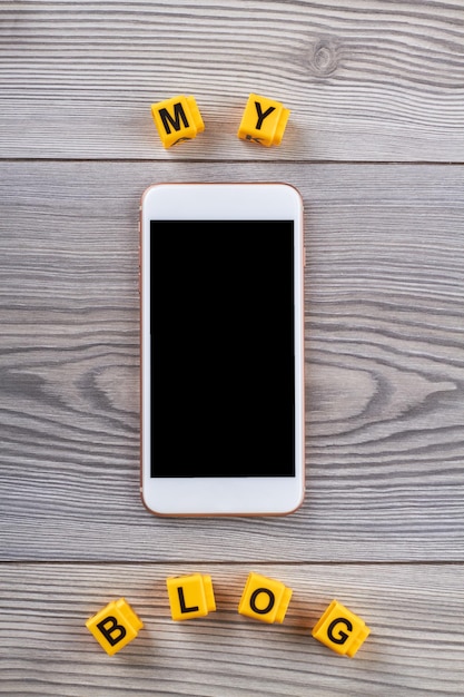 Smartphone avec écran blanc sur table en bois