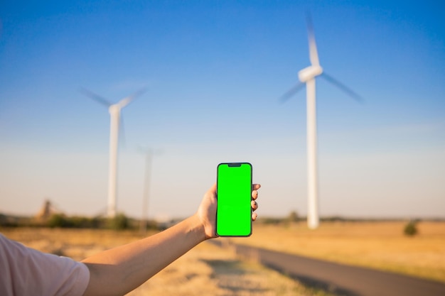 Smartphone à écran vert sur le fond des moulins à vent. Clé de chrominance. moulins à vent énergie verte