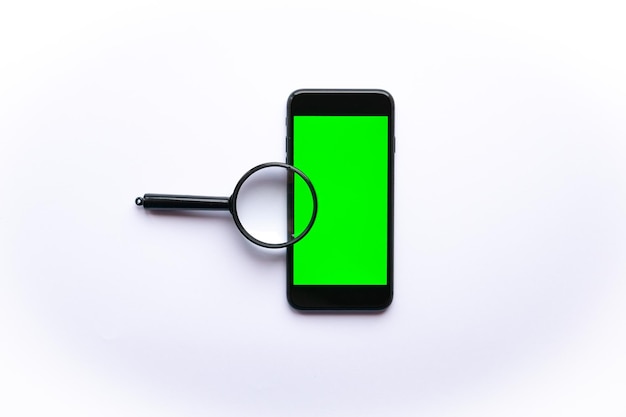 Smartphone avec écran vert et loupe isolé sur blanc, concept de recherche et d'analyse