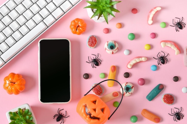 Un smartphone avec un écran vide sur fond de divers bonbons sur fond rose