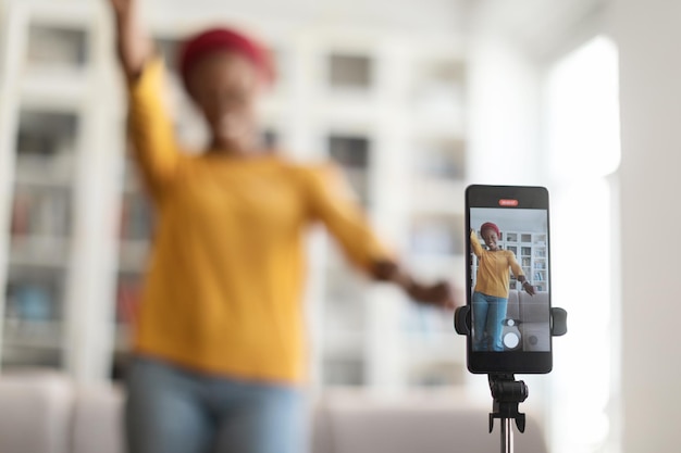 Smartphone enregistrant une influenceuse dansant à la maison