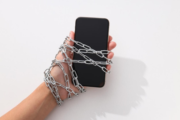 Le smartphone est enfermé dans une chaîne avec une serrure