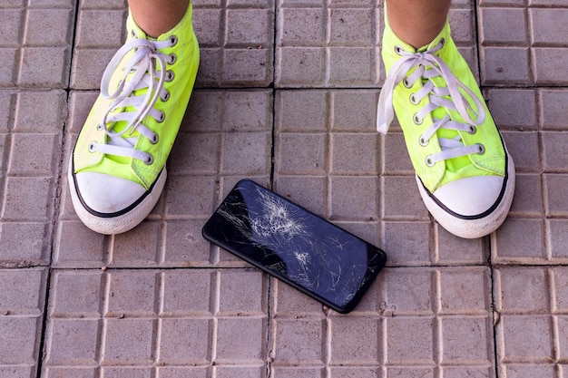 Un smartphone est tombé sur le sol avec un accident de téléphone portable avec vue de dessus d'écran cassé