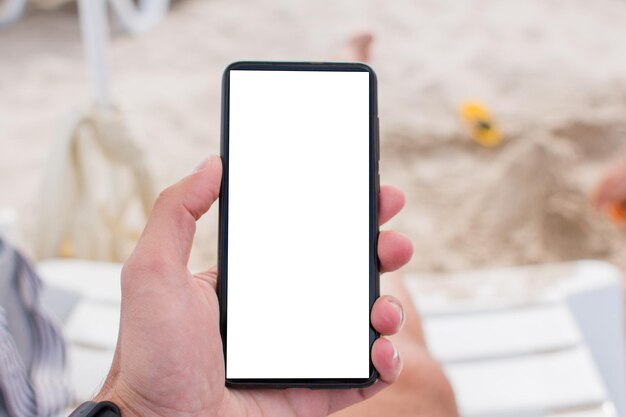 Smartphone à la main sur la plage