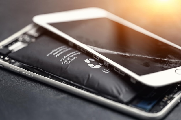 Smartphone moderne cassé en raison d'une batterie lithium-ion gonflée
