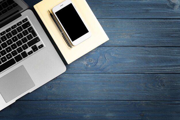 Photo smartphone et ordinateur portable sur table en bois bleue