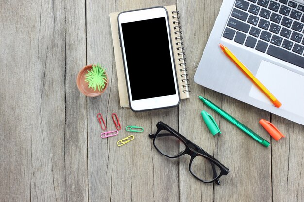 Smartphone et ordinateurs portables sur table.