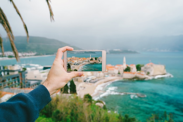 Smartphone avec une photo à l'écran dans la surface est la vieille ville de budva