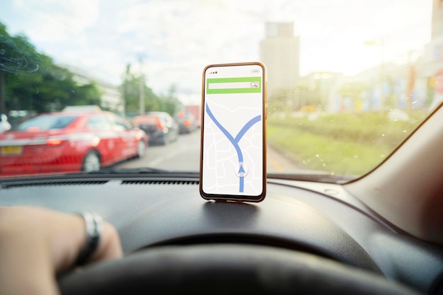 Smartphone placé sur le tableau de bord avec une carte de navigation pour aider