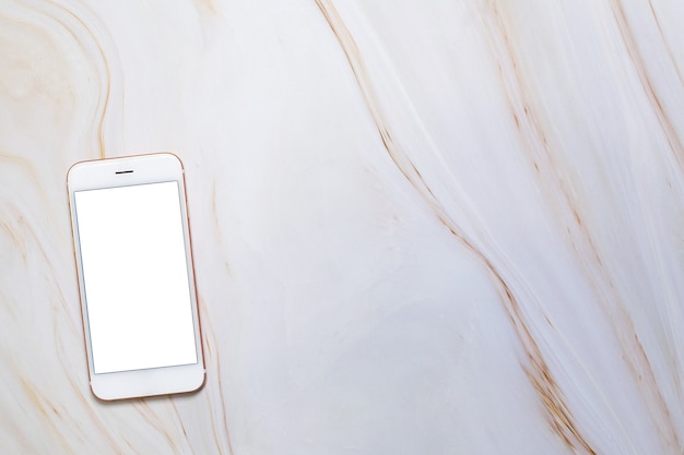 Smartphone à plat avec écran blanc vierge et copie-espace sur table en marbre.