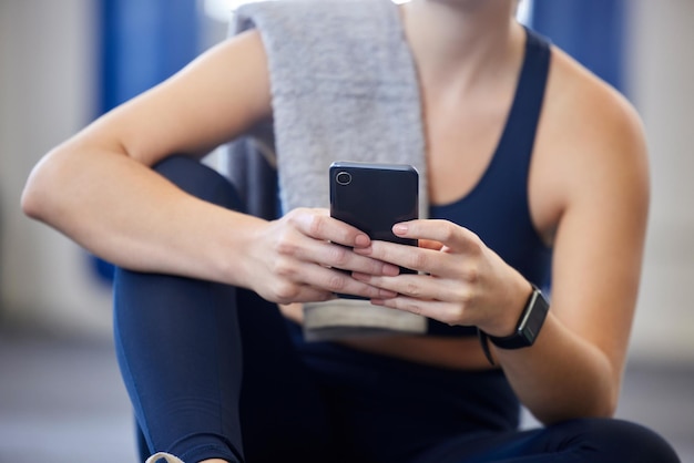 Smartphone de remise en forme ou relaxer le corps d'une femme en tapant défiler ou parcourir l'application de santé bien-être article de blog ou flux de gym sur les médias sociaux