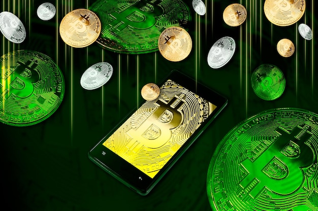 Smartphone avec symbole Bitcoin à l'écran parmi des tas de Bitcoins dorés et argentés sur fond vert