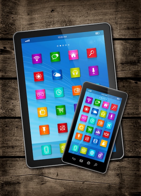 Smartphone et tablette numérique avec des icônes du bureau sur une table en bois sombre