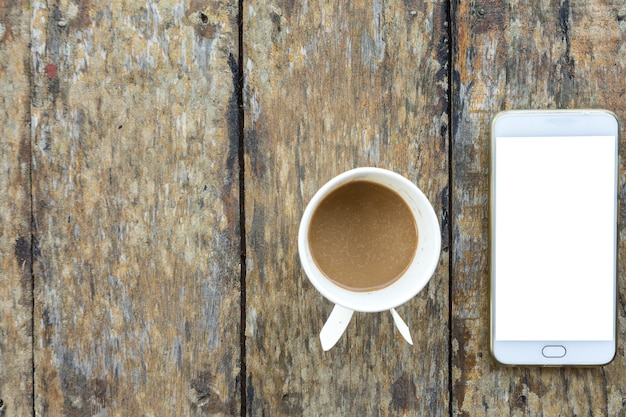 Smartphone et tasse de café en papier sur le vieux bureau en bois sur la vue de dessus.