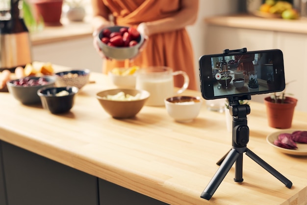 Smartphone sur trépied pendant la diffusion en direct du vlog de cuisine