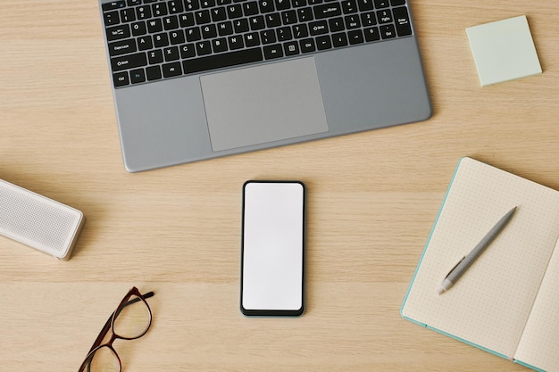 Smartphone vue de dessus minimal avec maquette d'écran blanc sur le lieu de travail du bureau