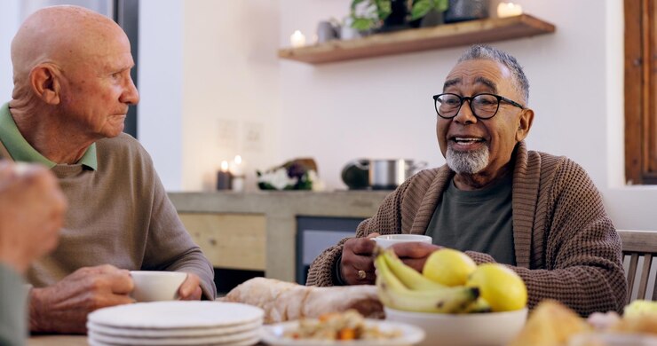 Photo smile tea party et un groupe de personnes âgées dans le salon d'une maison communautaire pour une retraite sociale d'amis ou une conversation avec des hommes et des femmes âgés ensemble dans un appartement pour une visite