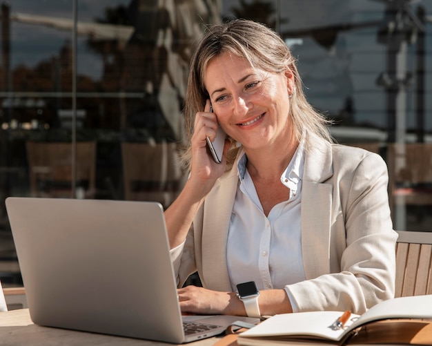 Smiley coup moyen femme travaillant à l'extérieur