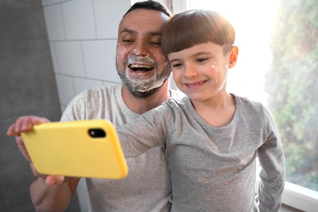 Photo smiley enfant et père prenant selfie coup moyen