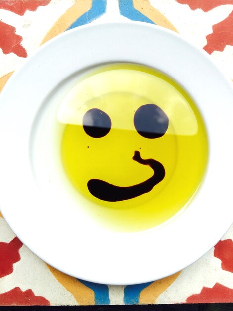 Photo un smiley fait avec de l'huile d'olive et du vinaigre dans une assiette