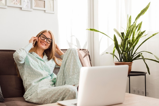 Photo smiley femme en pyjama travaillant à domicile