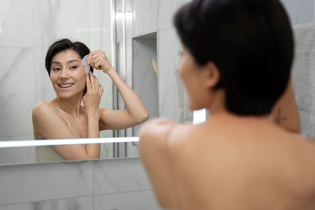 Smiley femme regardant dans le miroir se bouchent