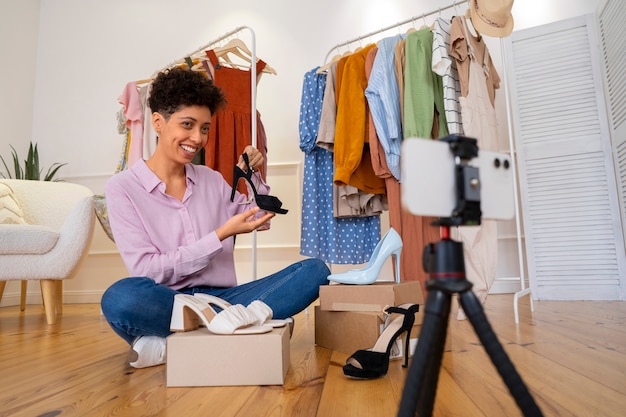 Smiley femme tenant une chaussure plein coup