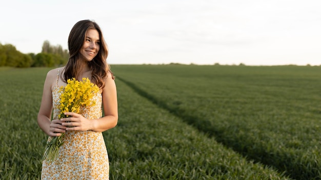 Smiley femme tenant des fleurs