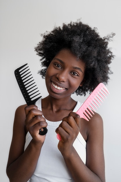 Photo smiley femme utilisant des peignes à cheveux vue de face