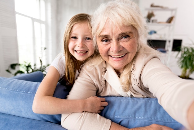 Photo smiley girl and grandma at home