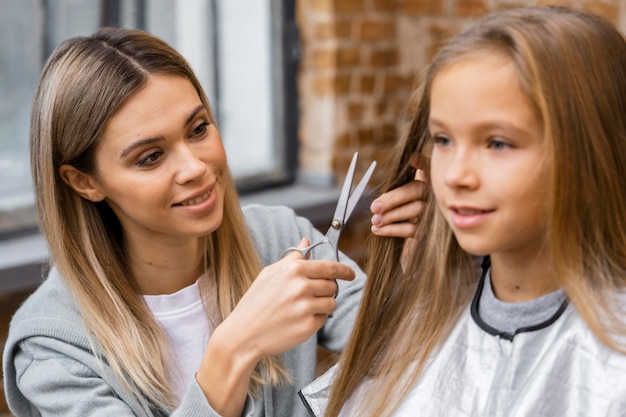 Photo smiley petite fille se coupe les cheveux