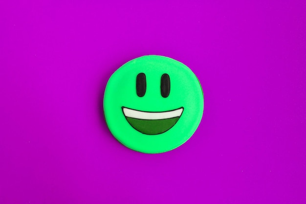 Smiley vert sous forme de pain d'épice sur le fond violet libre de l'espace de copie