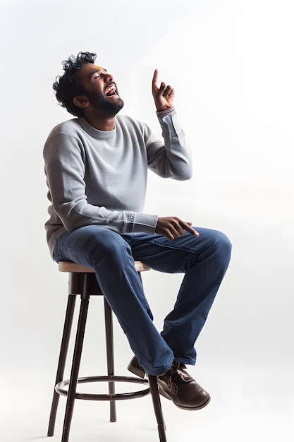 Photo smiling indian man in sweater sitting on chair and showing thumbs up